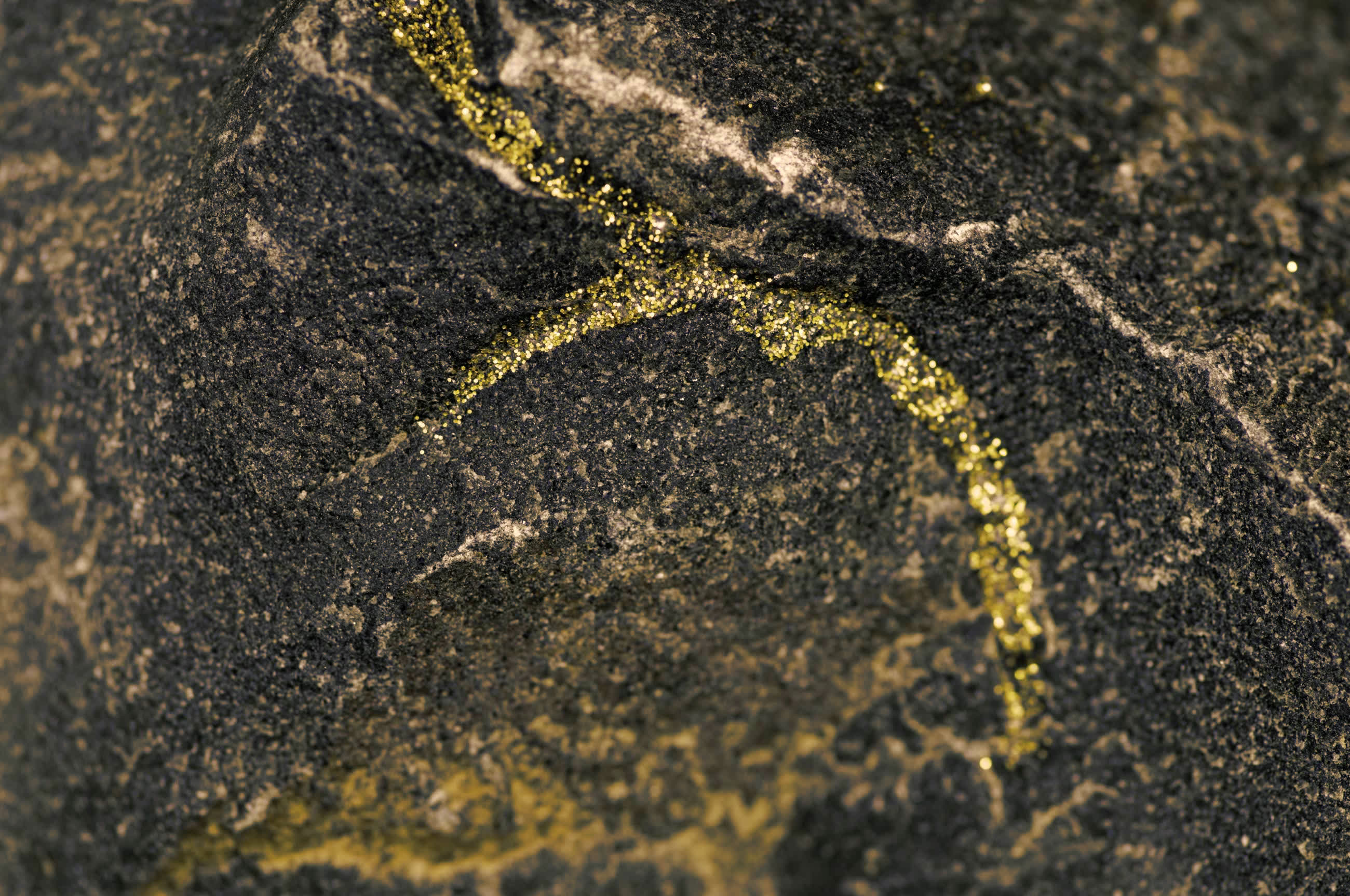 A gold seam running through dark stone.